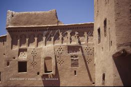 Image du Maroc Professionnelle de  La Kasbah de Taourirt fut édifiée au 17ème siècle par la tribu des Glaoui, située sur une colline au centre urbain de la ville d'Ouarzazate, cette remarquable ancienne bâtisse en pisé parfaitement conservée est l'une des plus belles constructions architecturales de la ville. La Kasbah qui ressemble à un grand château de sable incrusté dans le désert, fait partie du circuit touristique, elle a été classé Patrimoine Mondiale de l’Unesco. Ce véritable joyau de Ouarzazate permet au visiteur de découvrir l’intérieur d’une ksar où résident souvent la population berbères du sud du Maroc. Photo datant du Samedi 23 Août 1997. (Photo / Abdeljalil Bounhar) 